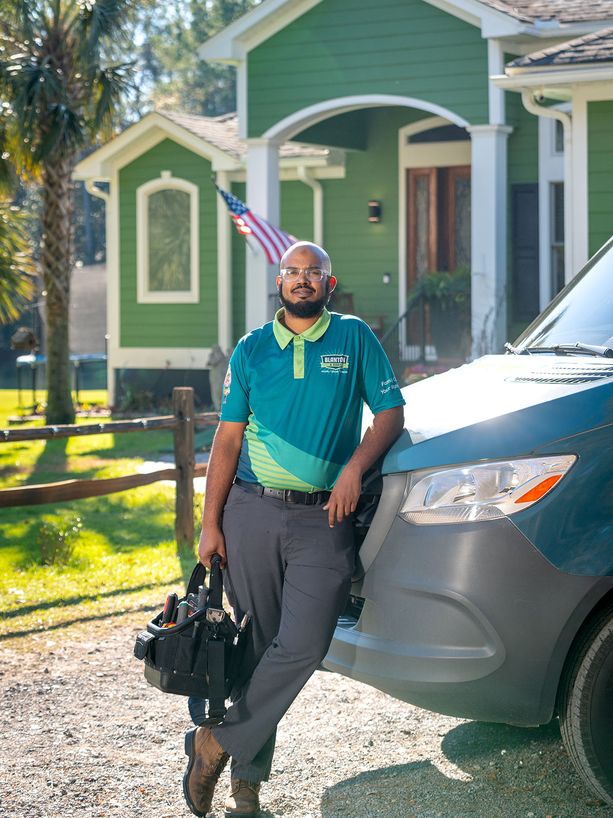 Blanton's tech stands beside his parked work van