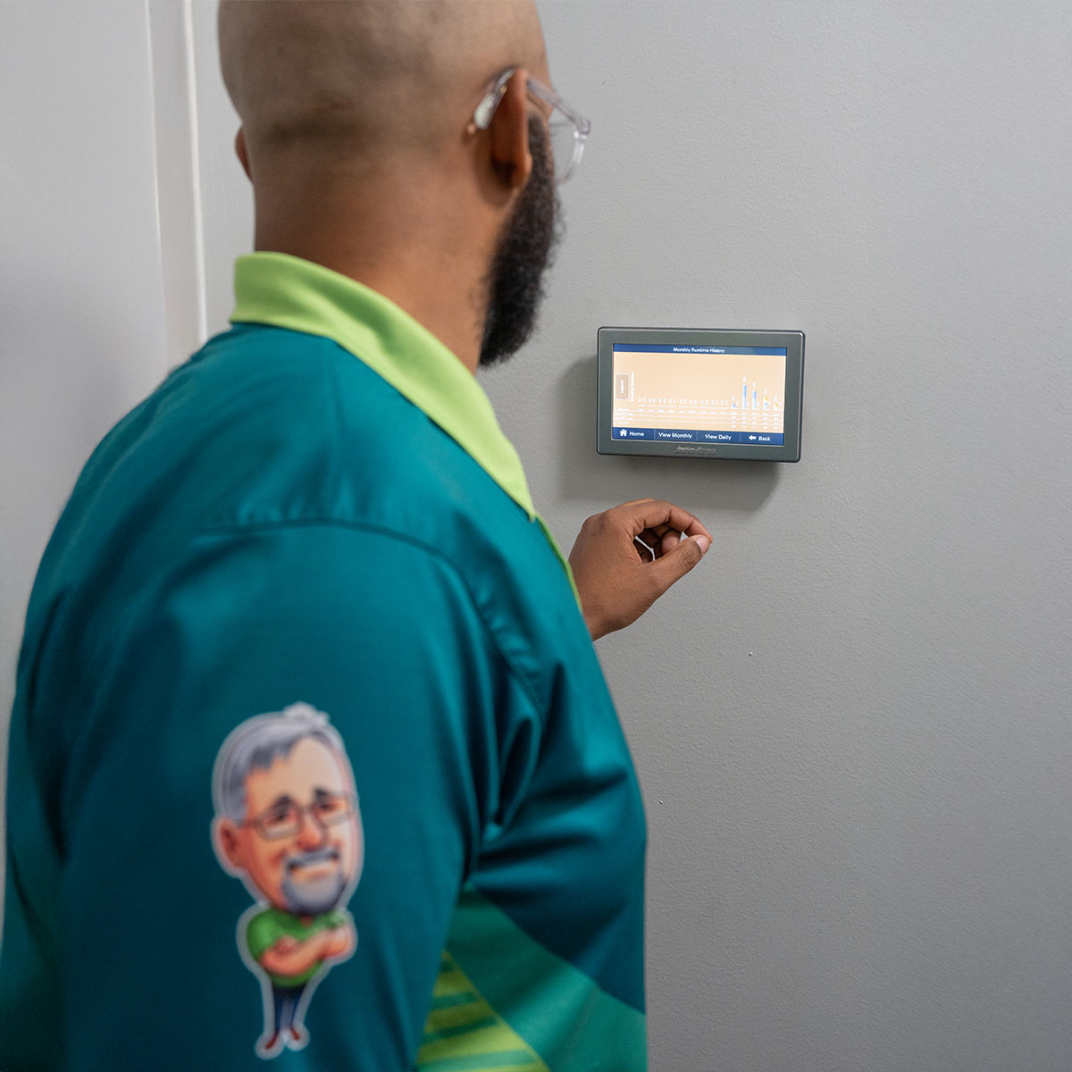 Blanton & Sons tech looking at smart thermostat