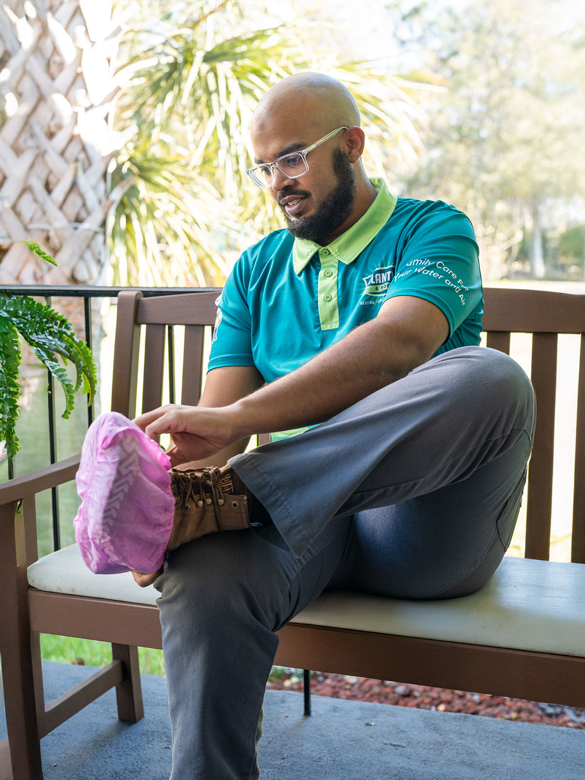Blanton tech sitting on a bench putting a pink shoe cover