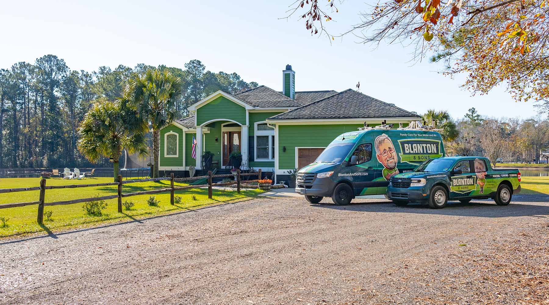 Two Blanton's trucks parked outside a green home