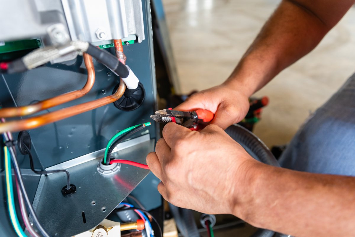 HVAC Tech fixing failing electrical components