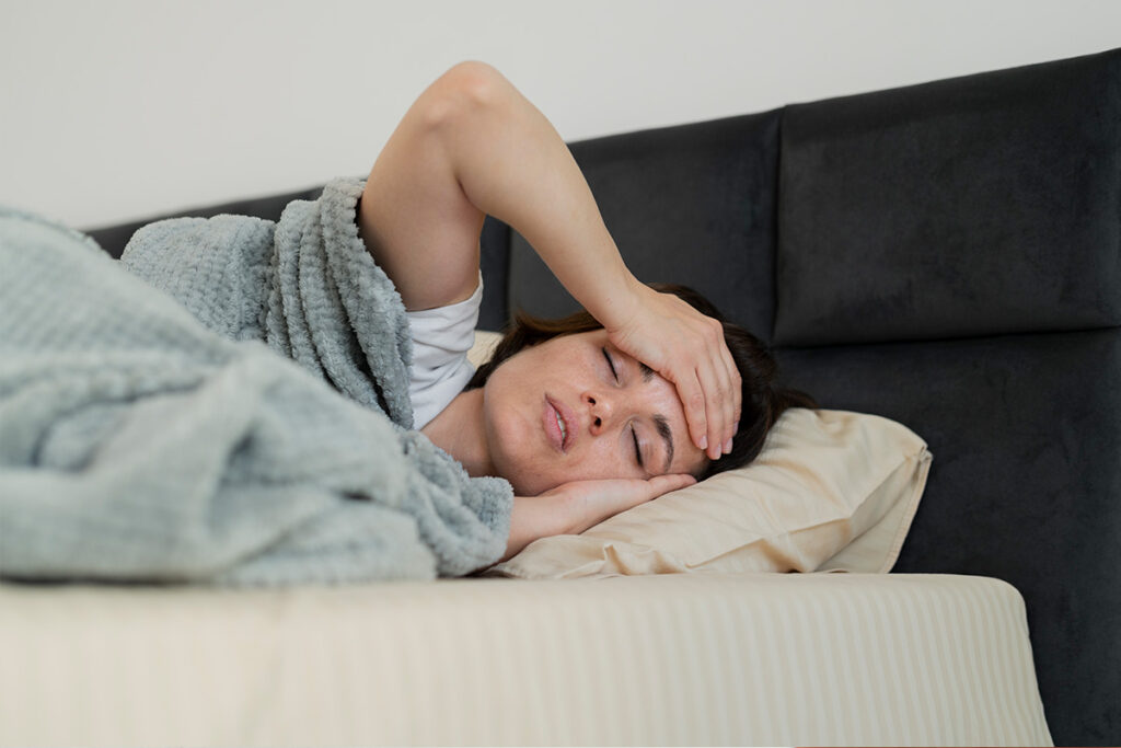 person feeling sick in their bed